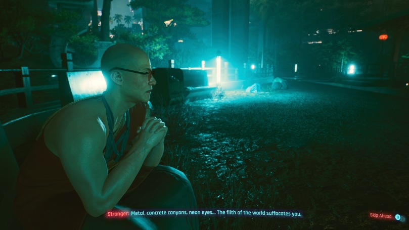 V sitting next to a monk in a dark park illuminated by some light-blue neon lamps.